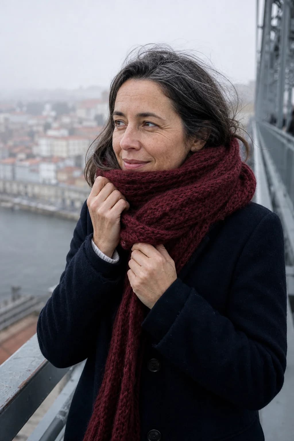 Mulher a ajeitar um cachecol bordeaux na Ponte D. Luís I